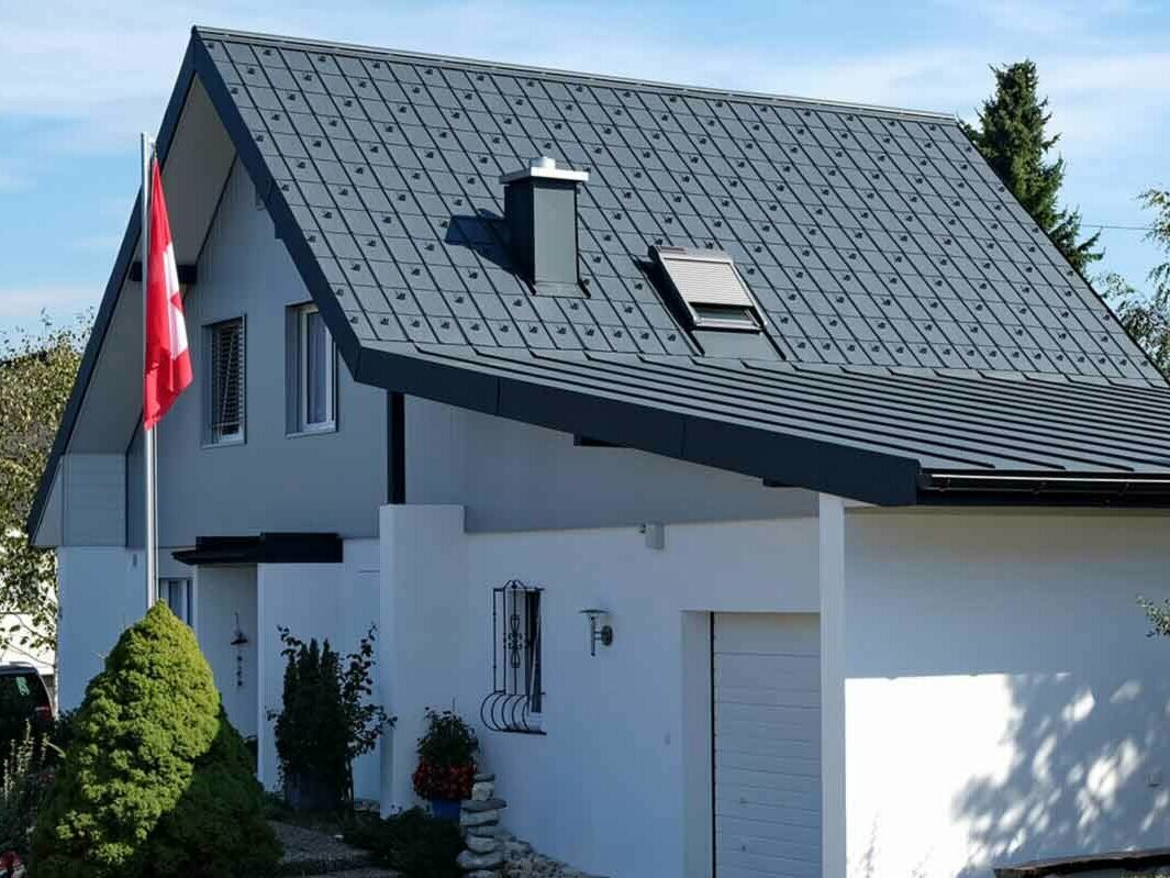 Haus mit Garage nach der Dachsanierung mit der PREFA Dachplatte in Anthrazit