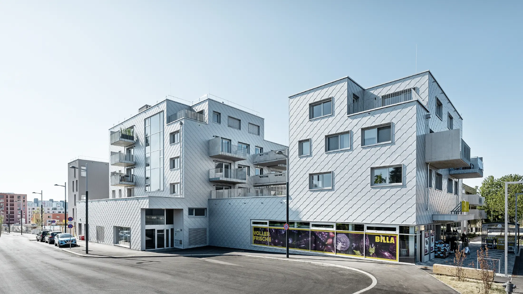 Complexe résidentiel à toit plat recouvert de losanges de façade 44 × 44 PREFA en argent métallisé.
