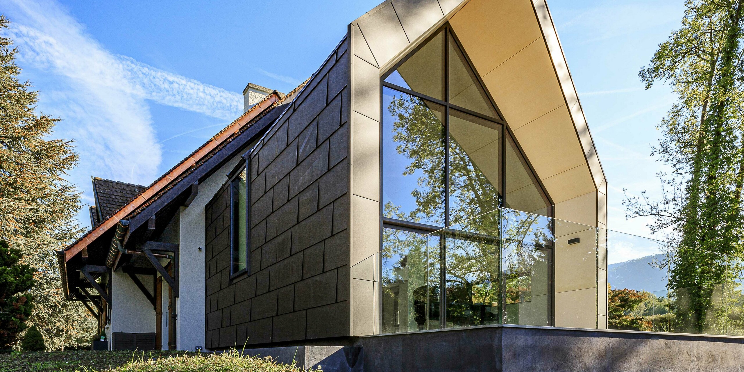 Panneaux de toiture et de façade FX.12 PREFA en P.10 brun comme élément de design contrasté sur l'extension d'une maison individuelle à Lully.