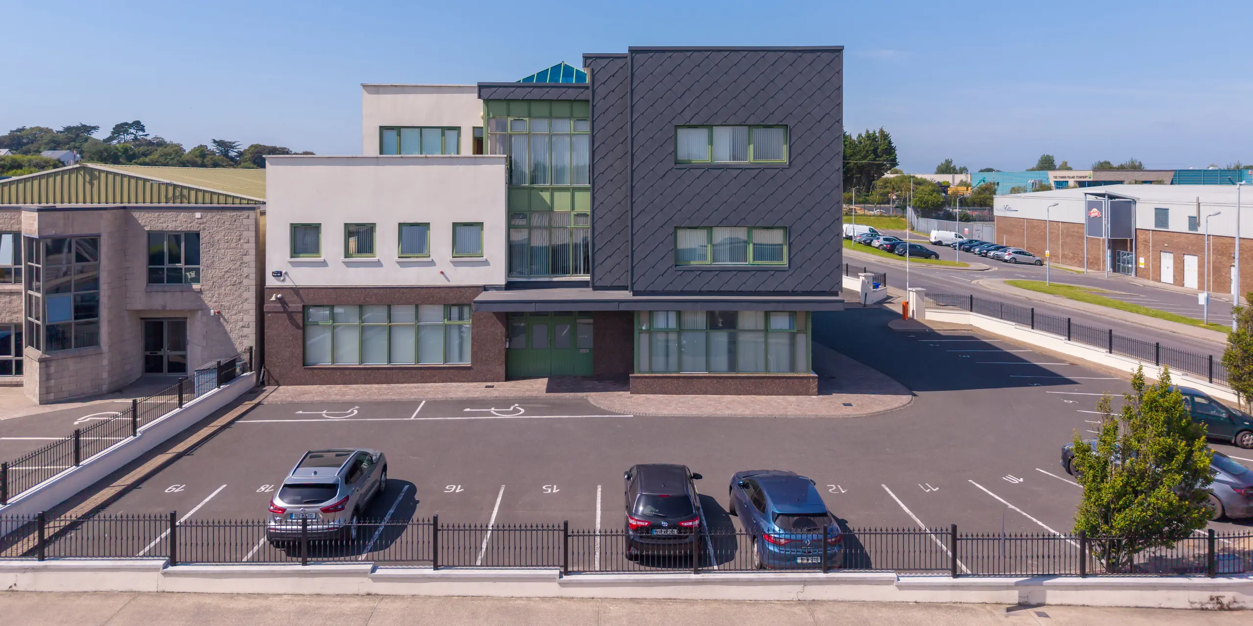 Vue d'ensemble du centre de santé mentale pour enfants et adolescents de Wexford, en Irlande. La remarquable section du bâtiment, revêtue de losanges de façade 44 x 44 PREFA en P.10 gris sombre, attire immédiatement le regard ; leur motif losange précis confère à la façade une allure moderne et dynamique. L'élégante façade en aluminium contraste fortement avec les éléments architecturaux clairs et les grandes surfaces vitrées. Durable et résistant aux intempéries, le système de façade PREFA allie qualité architecturale et grande fonctionnalité, et souligne le caractère contemporain du centre de santé.