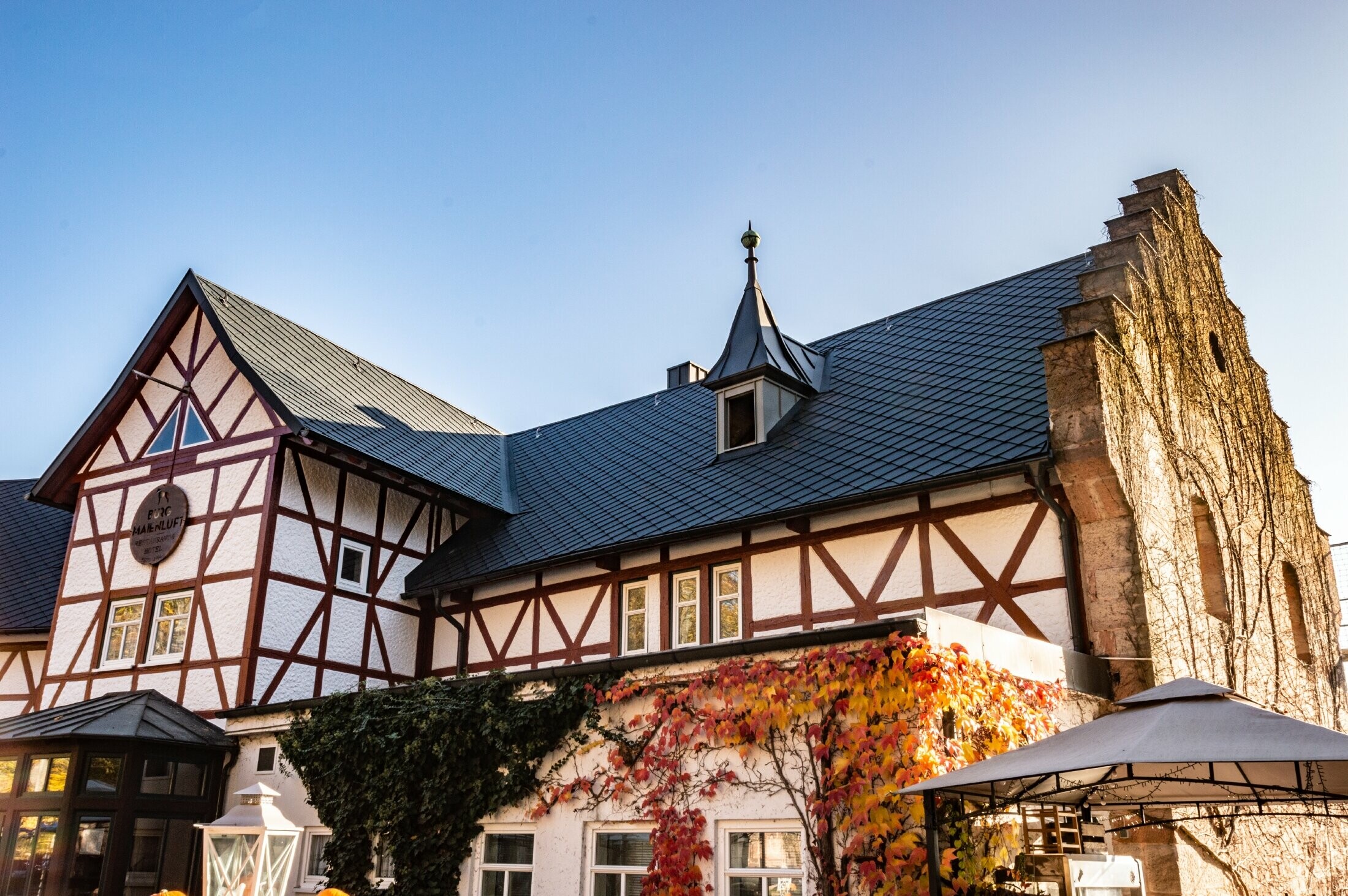 L’hôtel Burg Maienluft a été recouvert de losanges de toiture 29 × 29 PREFA couleur anthracite, la façade est à colombage.