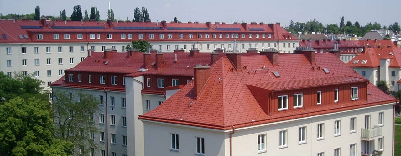 Vue des bâtiments d’habitation du lotissement Hugo Breitner Hof à Vienne. Les toits ont été recouverts de bardeaux PREFA rouge tuile.