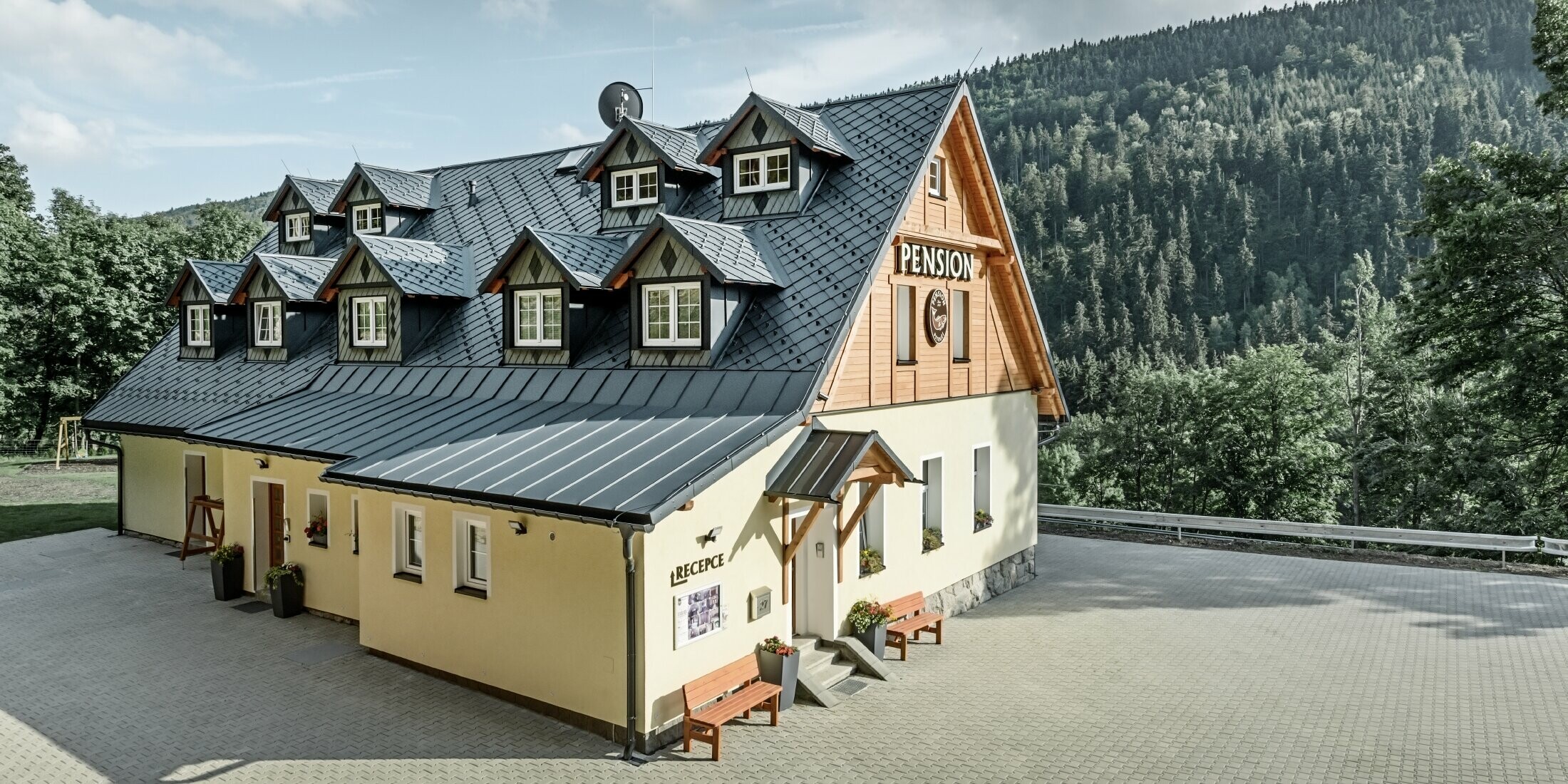 Pension in Tschechien mit Steildach und vielen Gauben eingedeckt mit Aluminiumdach von PREFA, schuppiges Rautendach mit Schneeschutz