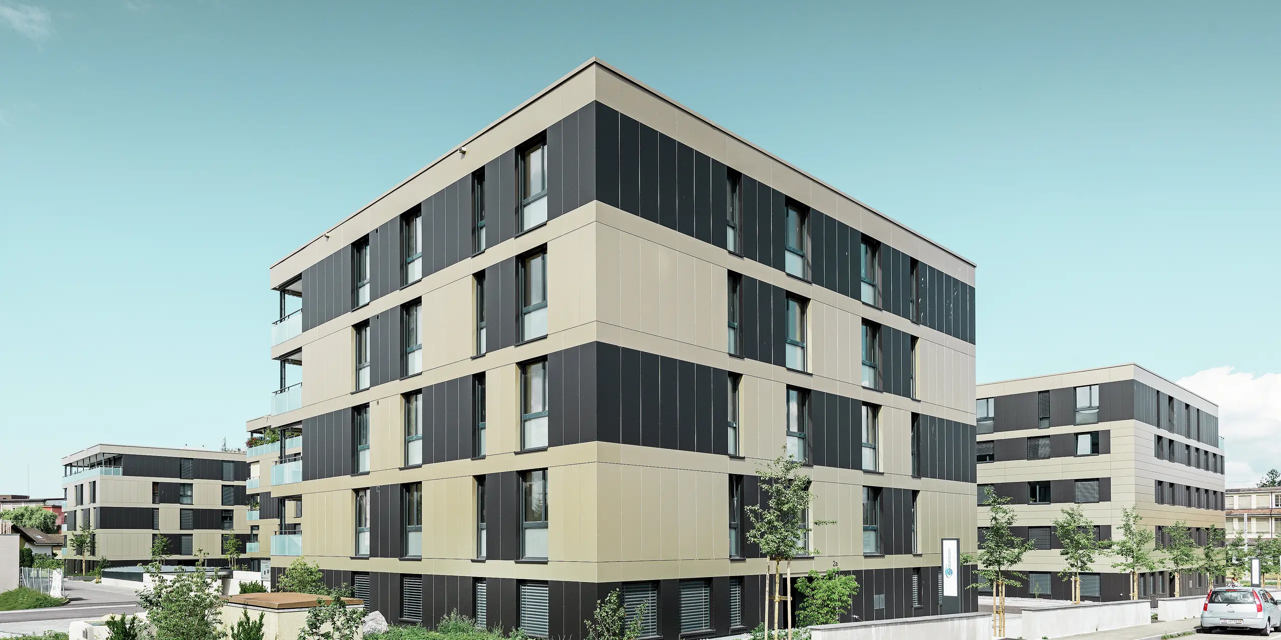 Complexe résidentiel aux immeubles cubiques — Façades en aluminium PREFA de couleur bronze avec des éléments gris noir