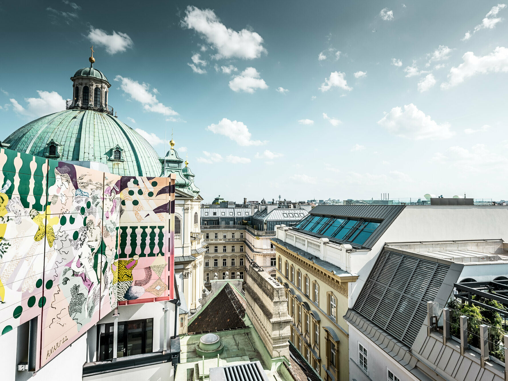 Blick vom Dach aus auf die umliegende Umgebung: Ein Teil der Peterskirche und mehrere Wohnbauten sind zu sehen.