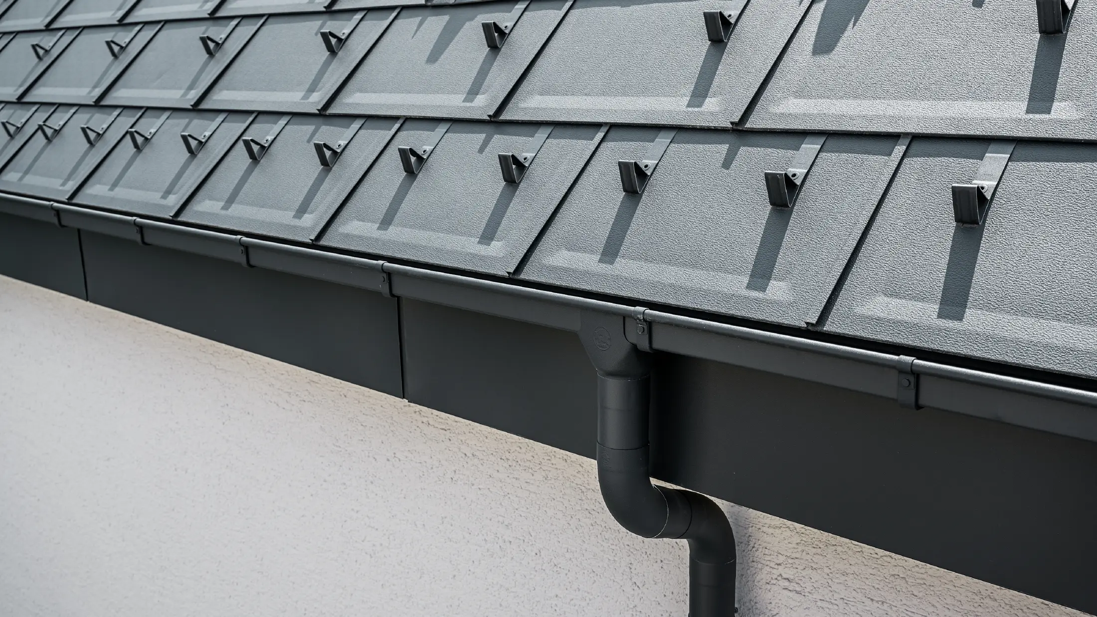 Surface de toit raide recouverte de R.16 avec gouttière carrée, naissance et descente de gouttière PREFA couleur anthracite
