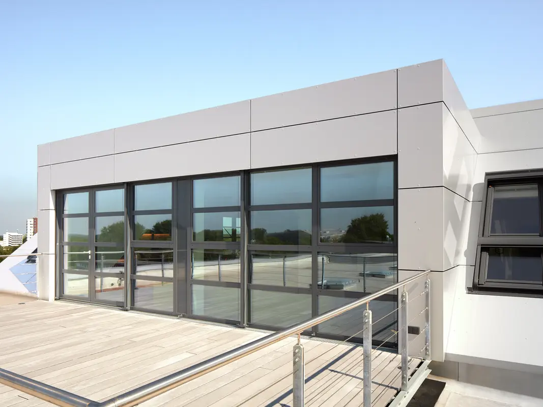 Sur l'imagine on peut apercevoir le toit-terrasse et la grande baie vitrée du bâtiment einsteineins à Kiel, qui a été revêtu en panneaux composites en aluminium Prefabond.