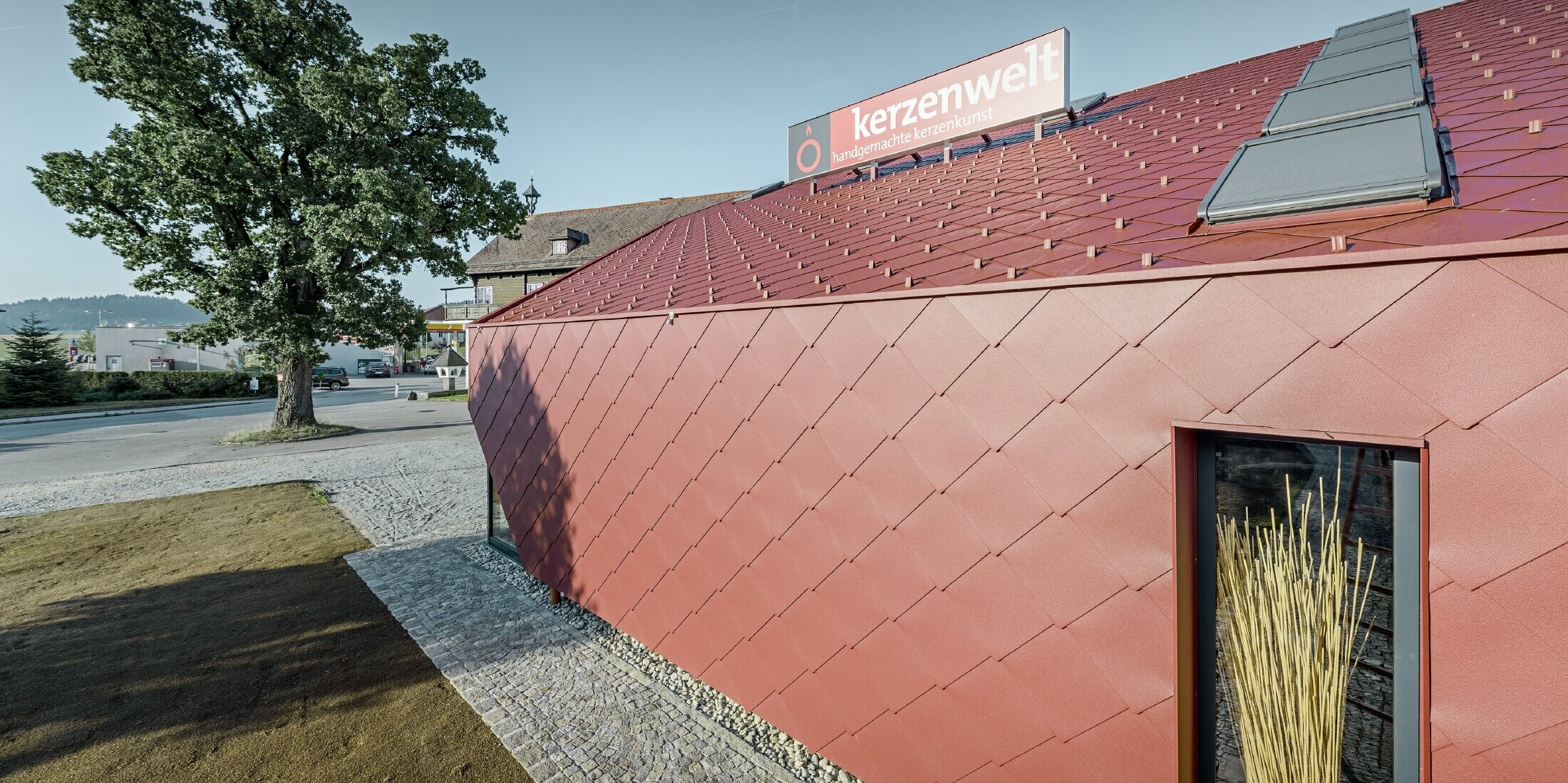 Die Kerzenwelt in Schlägl wurde mit der PREFA Raute rundum neu eingedeckt. Die Dacheindeckung und die Fassadenverkleidung wurden mit der Raute 44 × 44  in Oxydrot durchgeführt.