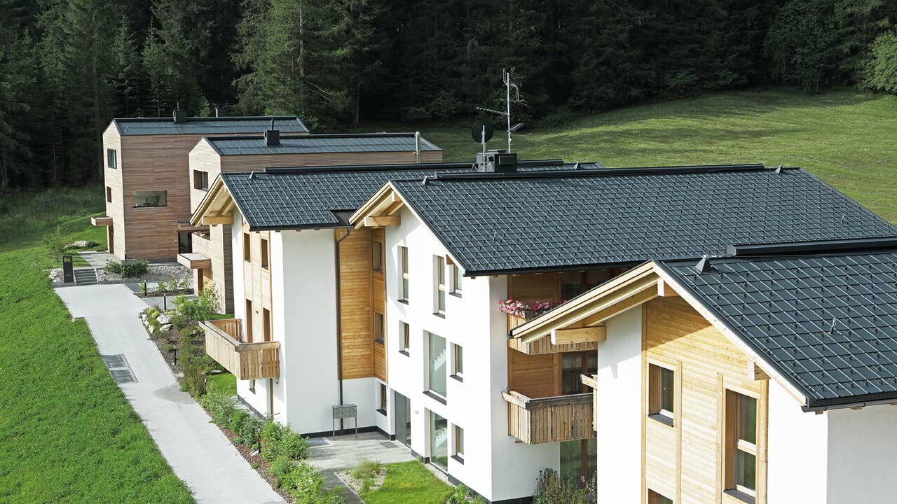 Aufnahme der fünf Wohnbauten in Corvara, eingedeckt mit der PREFA Dachplatte und Stehfalz in Anthrazit aus sturmsicherem Aluminium