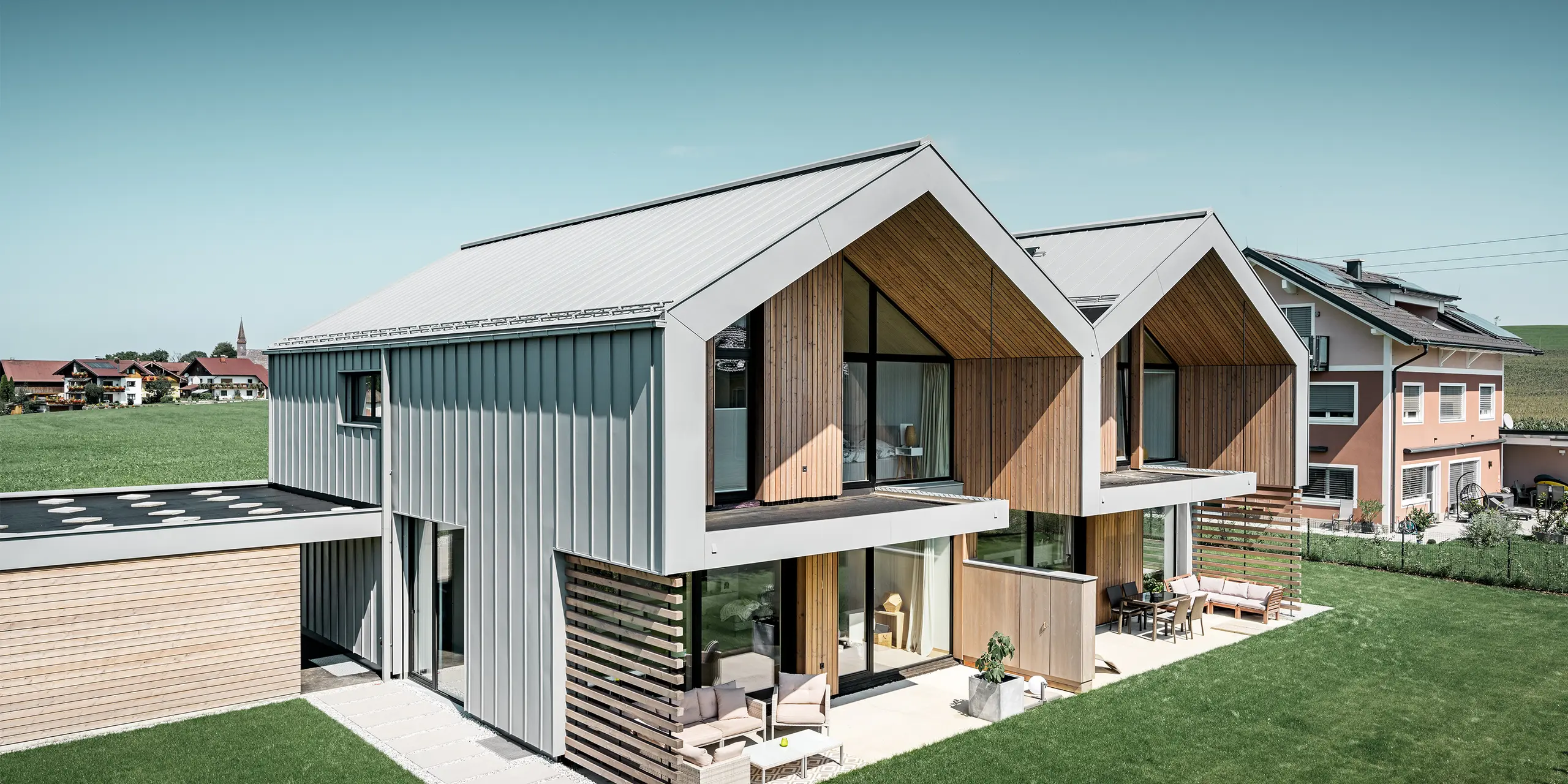 moderne Doppelhäuser mit PREFALZ Gebäudehülle, Dach und Fassade sind mit PREFALZ in Patina grau verkleidet inkl. Quadratrohr