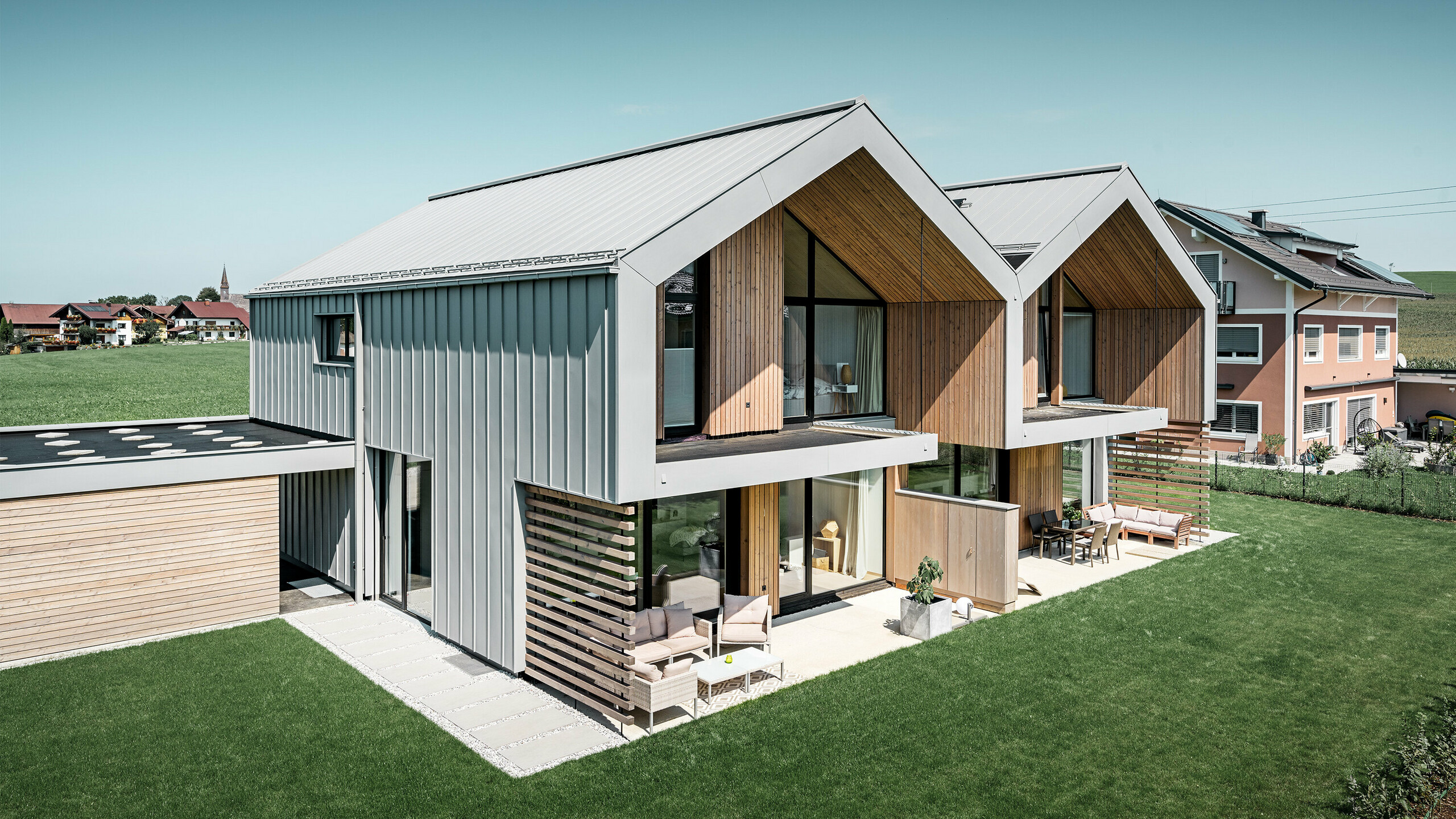 Maisons jumelées modernes avec enveloppe de bâtiment PREFALZ, le toit et la façade sont habillés de PREFALZ couleur gris quartz, tuyau de descente carré compris