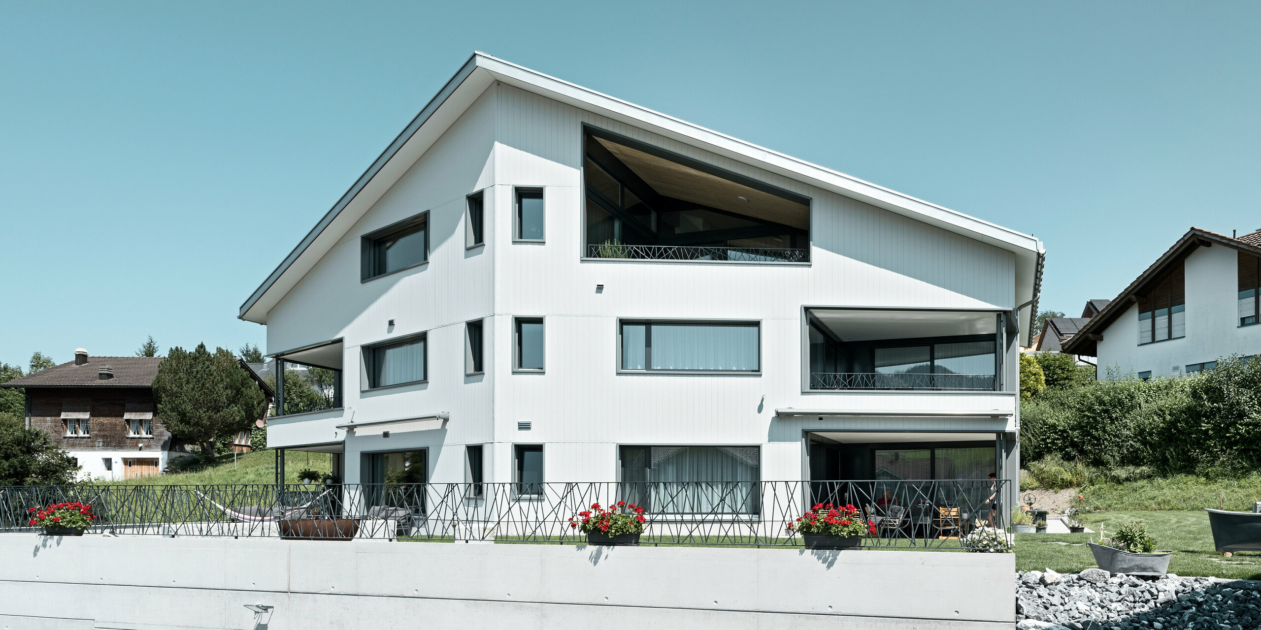 Sidings PREFA en gris pierre P.10 et blanc Prefa P.10 sur les façades de deux immeubles d'habitation voisins à Weissbad, en Suisse.