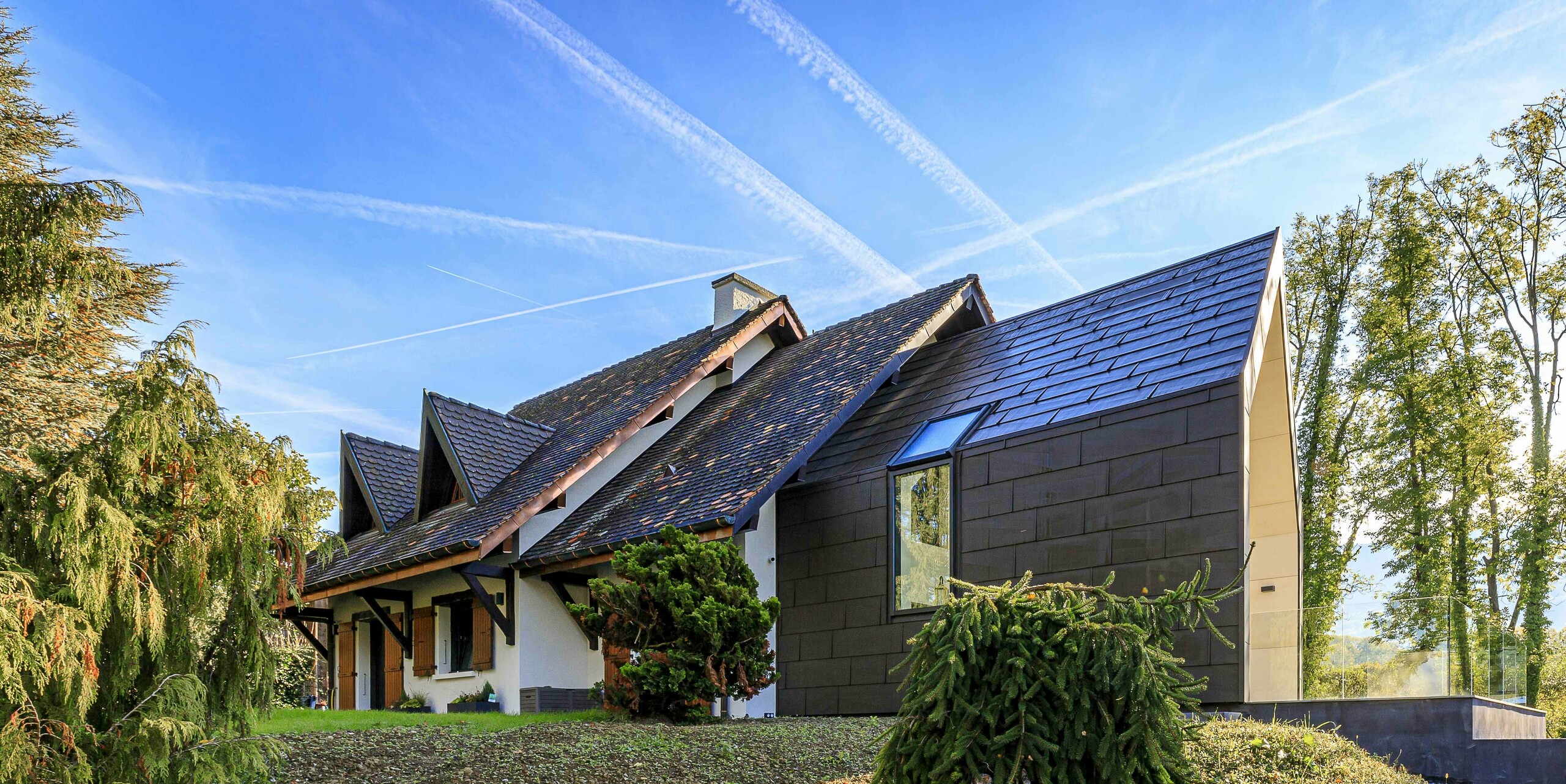 Panneaux de toiture et de façade FX.12 PREFA en P.10 brun comme élément de design contrasté sur l'extension d'une maison individuelle à Lully.