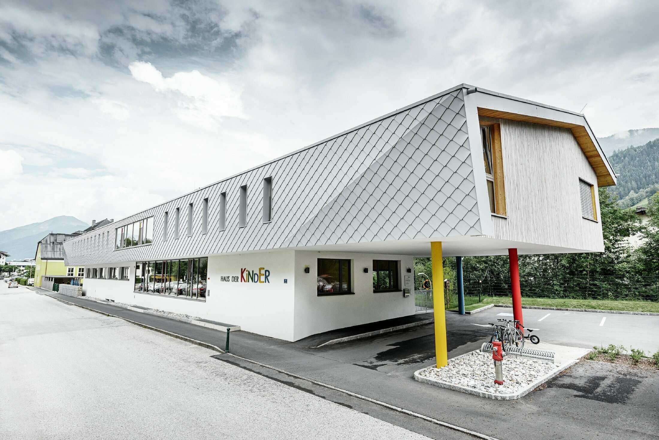 Nouvelle école maternelle de Kaprun — Façade moderne en aluminium réalisée avec des losanges de façade PREFA couleur blanc prefa