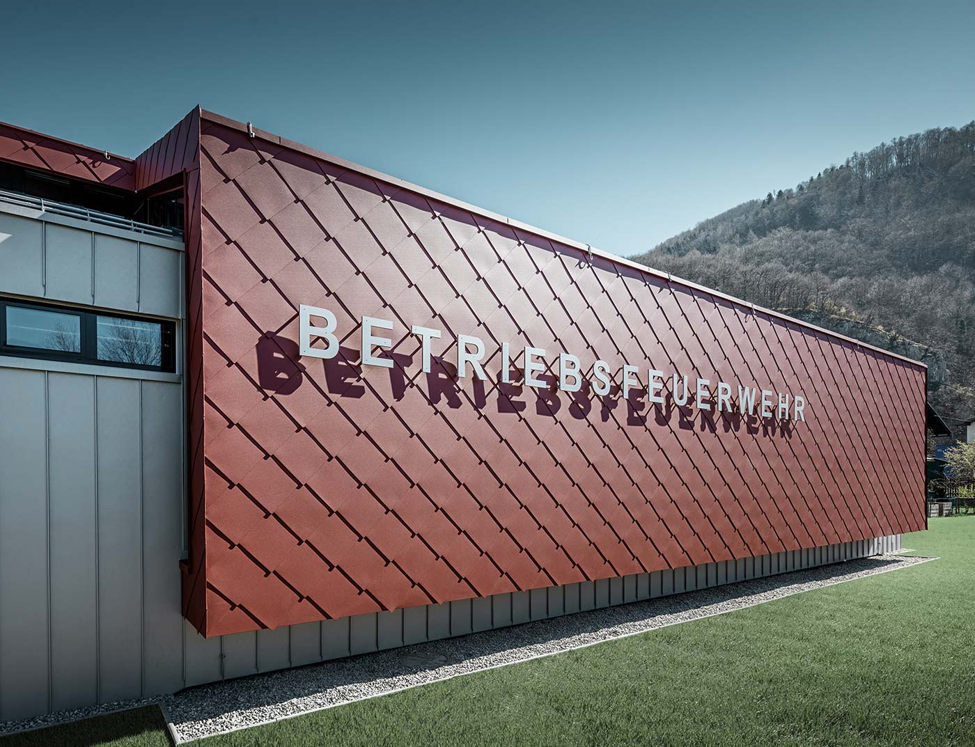 Une partie de la façade des sapeurs-pompiers des entreprises Neuman et PREFA à Marktl à été revêtue de losange PREFA 44 × 44 en rouge oxyde.