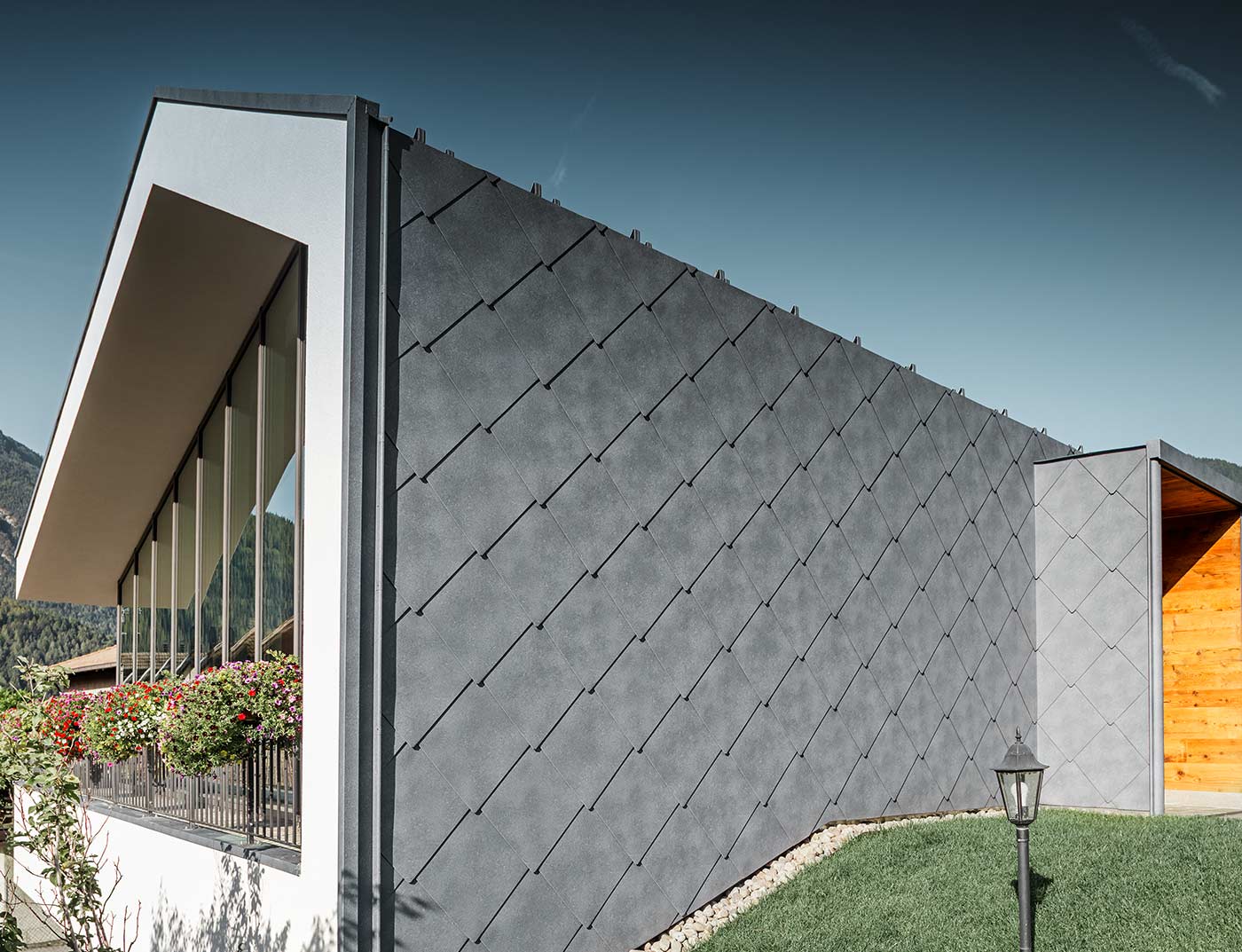 Le salon de beauté moderneà été revêtu de losanges 44 x 44 gris pierre sur le toit et la facade, avec une gouttière non visible.